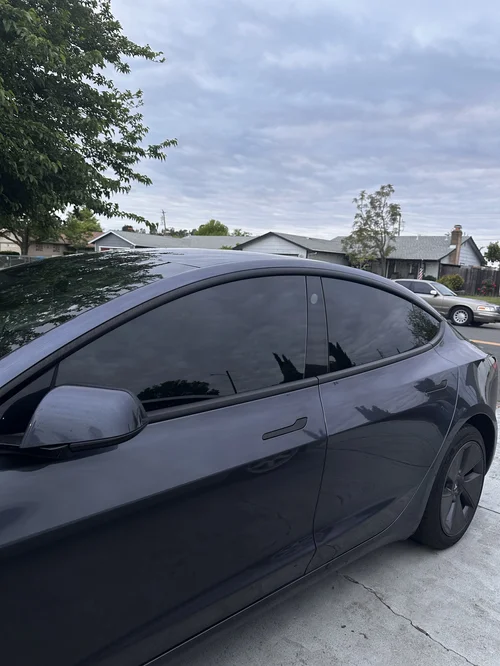 Side profile of a tinted sedan showing the front side window and the darker rear side window